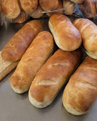 A cluster of freshly baked bread rolls arranged neatly on a wooden table.